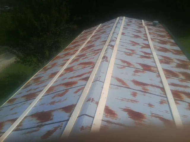 Rusted metal roof panels with new wood purlins before replacement — Storm Damage Roof Repair in Centerville by Roofing Brothers